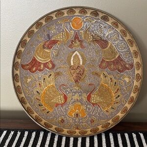 vintage enameled brass decorative plate with a vibrant peacock and floral design